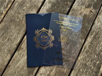 Orta kısmında pencere kesimi ve altın desenler bulunan lacivert renkte zarf ve sağında varak baskılı saydam davetiye.